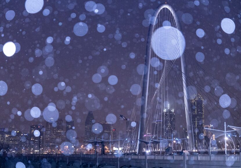 The Margaret Hunt Hill Bridge is seen as rain falls on downtown Dallas with temperatures...