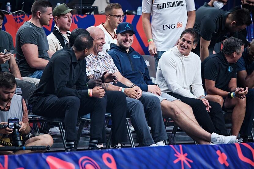 Luka Doncic (blue cap) sits courtside with members of the Mavs front office after Slovenia's...