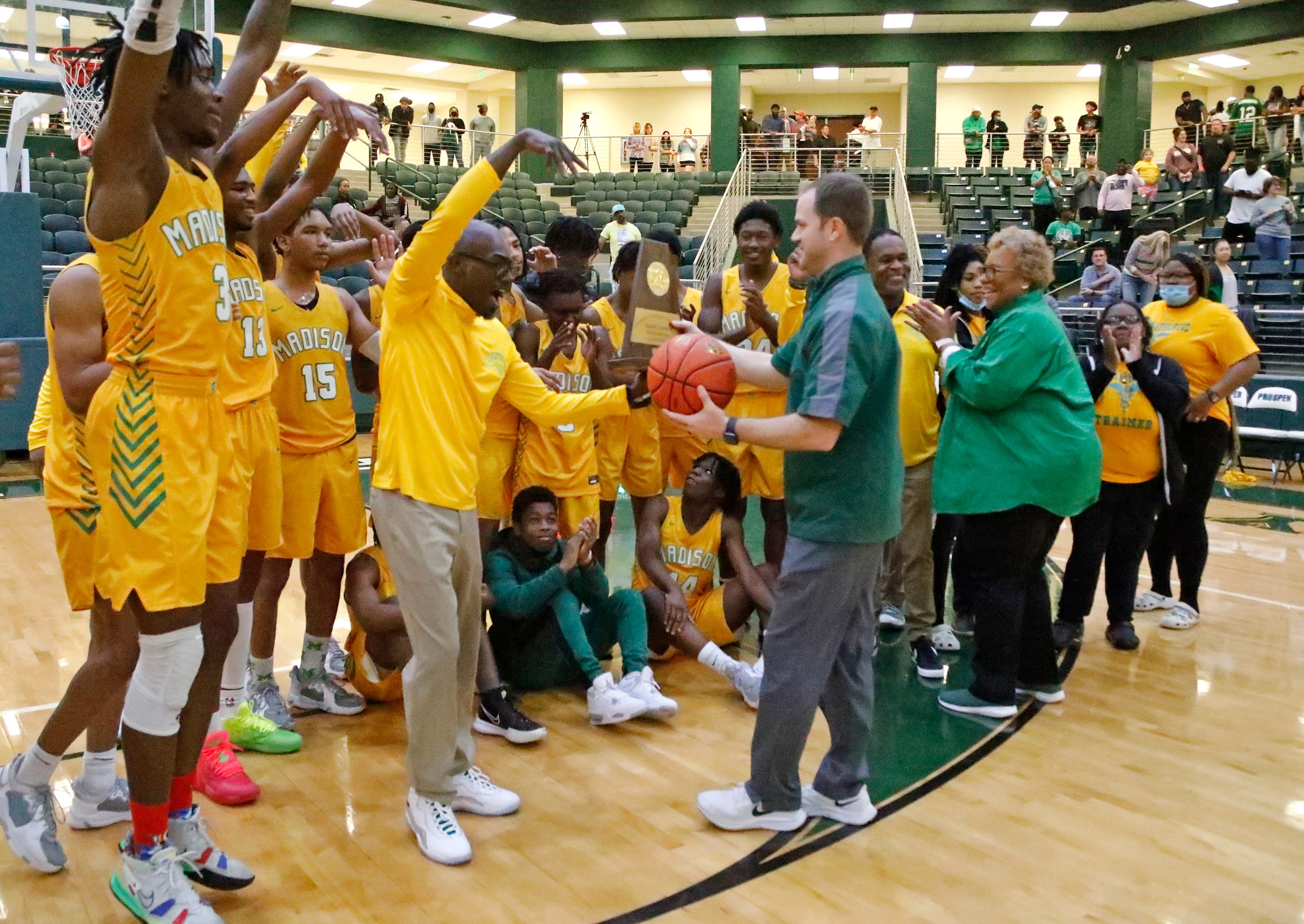 Madison head coach Damien Mobley receives the trophy and game ball after his victory in the...