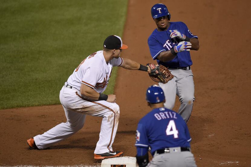 Baltimore Orioles first baseman Chris Davis, left, reaches out to tag out Texas Rangers'...