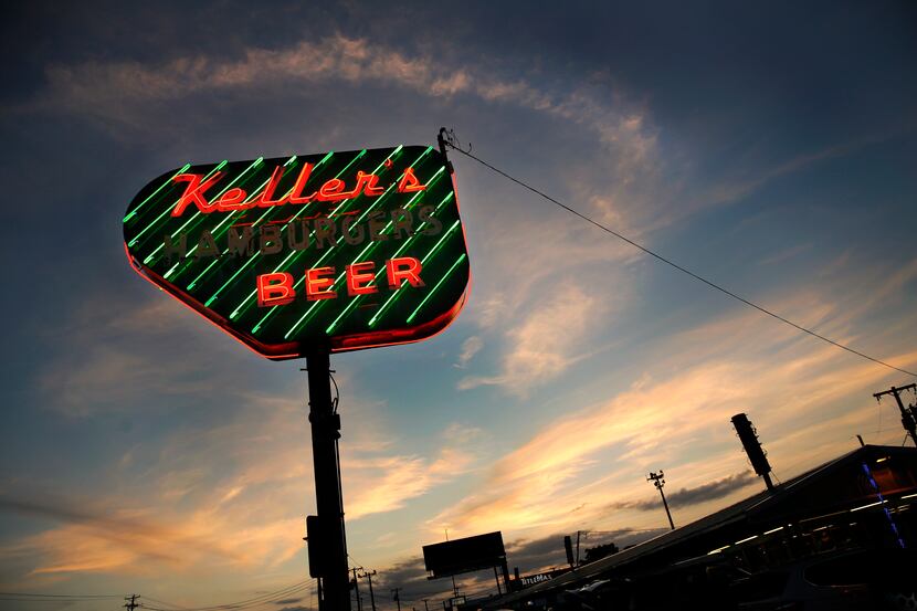 The sun sets behind Keller's Drive-In's neon sign.