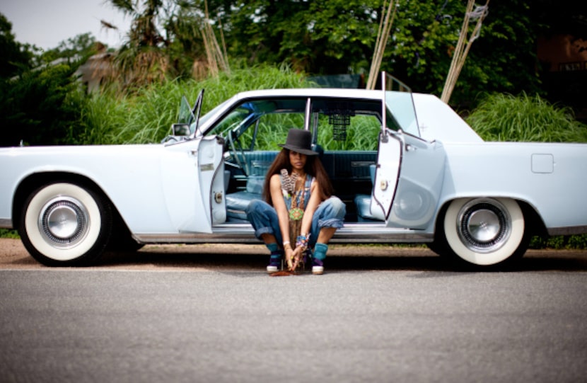 Erykah Badu nestled between the suicide doors of her 1964 Lincoln Continental