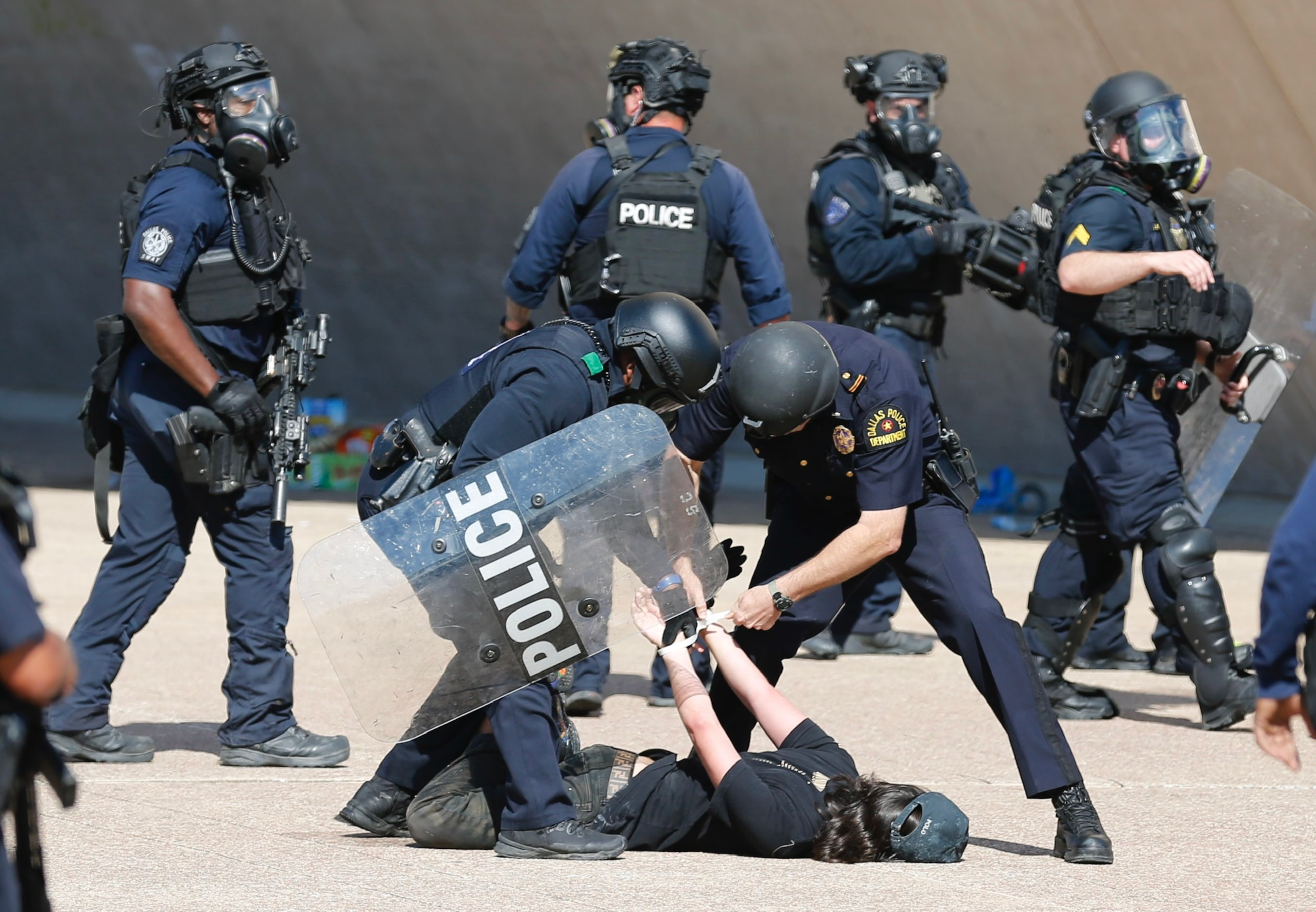 A protester is detained during a demonstration against police brutality in downtown Dallas,...