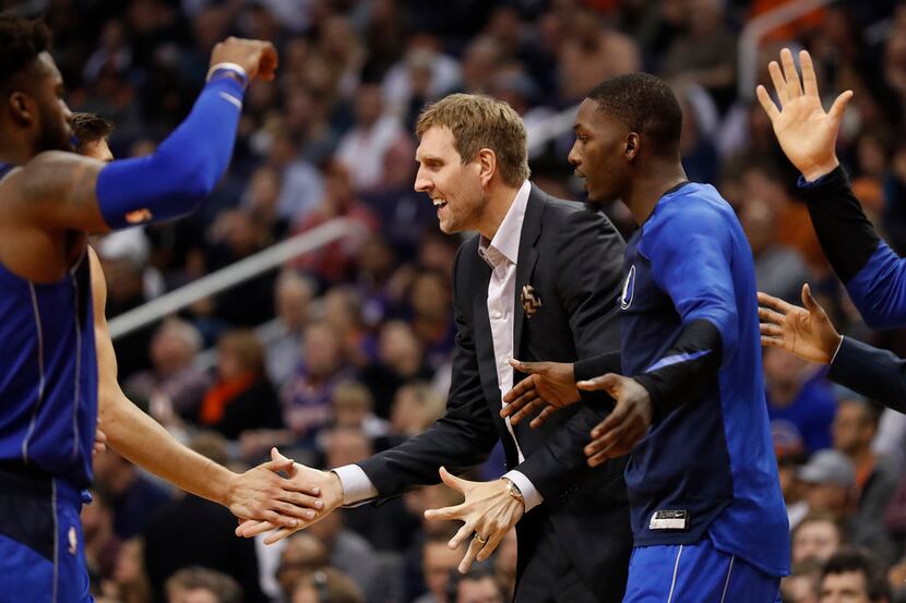 Dallas Mavericks forward Dirk Nowitzki greets his teammates during a timeout during the...