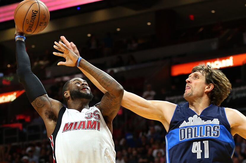 The Miami Heat's Willie Reed shoots against the Dallas Mavericks' Dirk Nowitzki (41) in the...