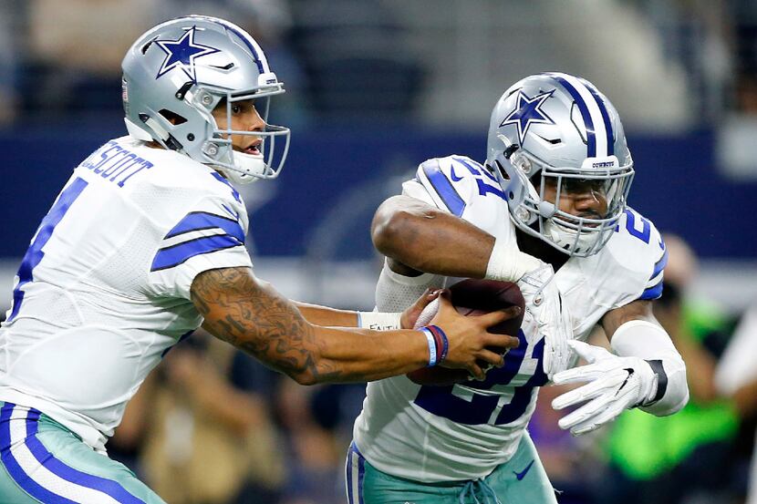 Dallas Cowboys quarterback Dak Prescott (4) fakes the handoff to running back Ezekiel...