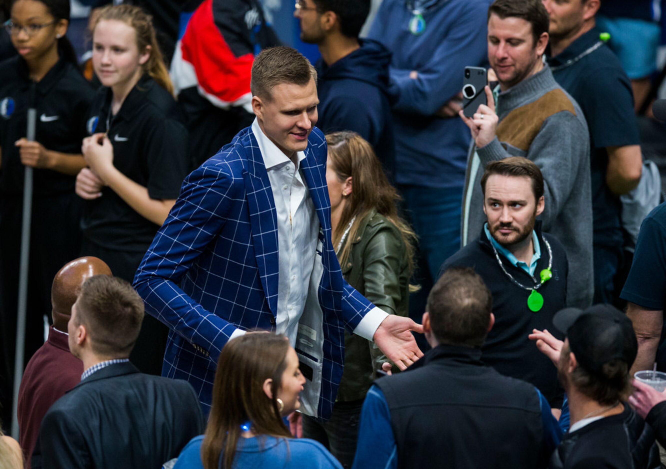 Dallas Mavericks forward Kristaps Porzingis (6) high-fives fans as he leaves the court after...