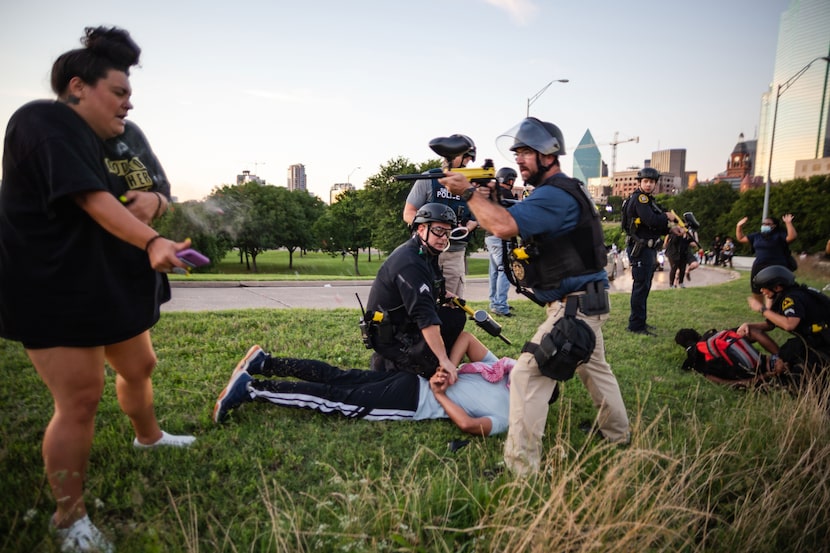 Jantzen Verastique recoils from a pepper ball fired by Dallas police Sgt. Roger Rudloff...