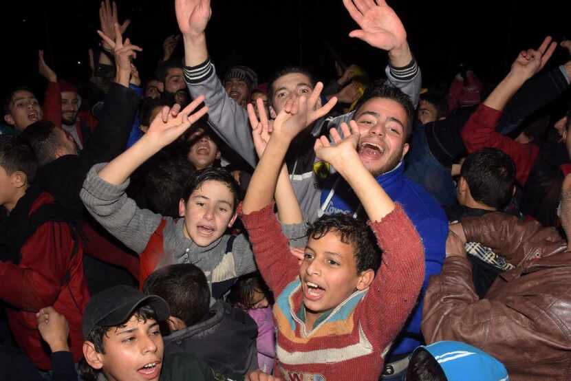 Syrians celebrate on December 12, 2016 in the government-held Mogambo neighbourhood of the...