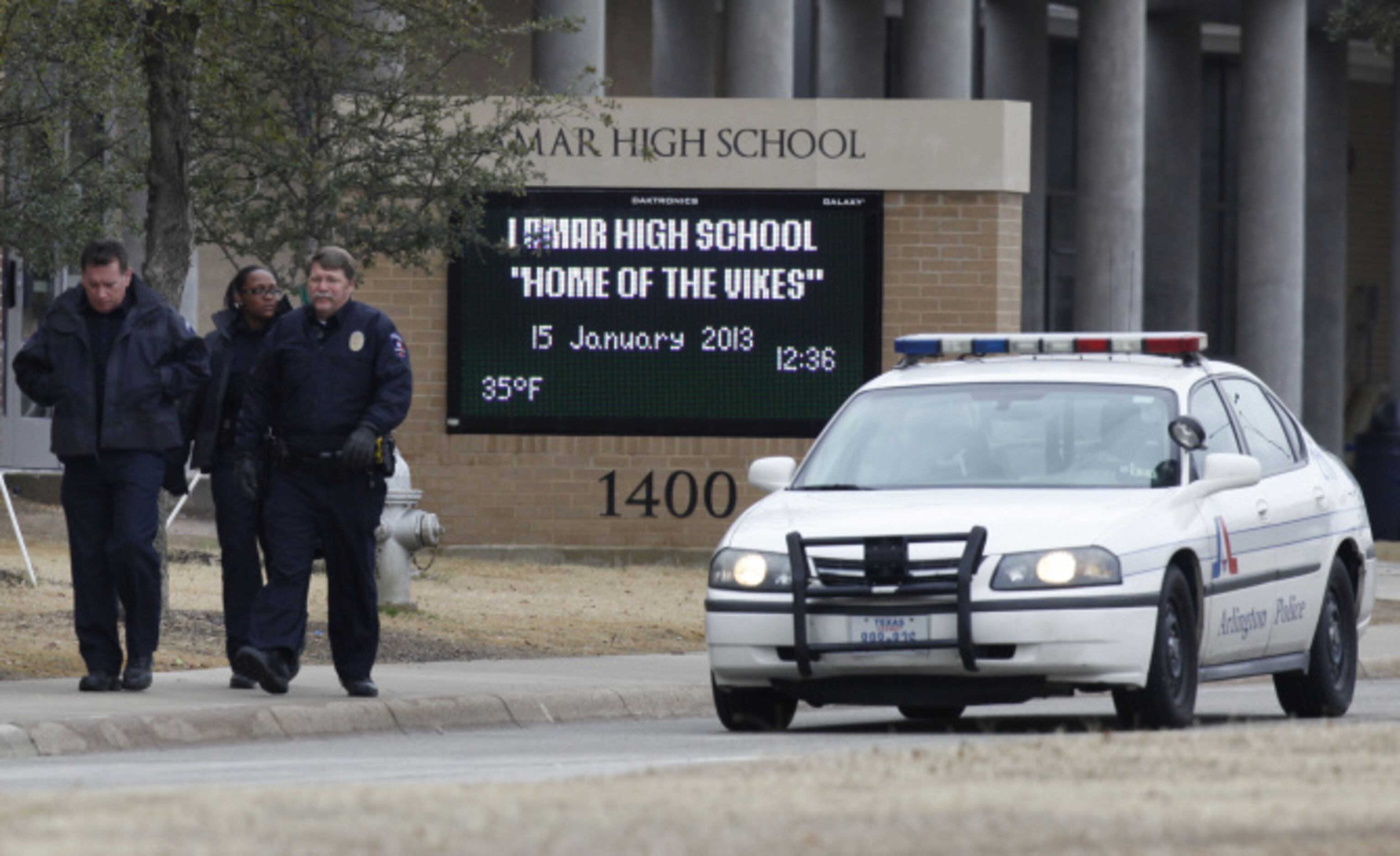 Arlington police walk out of Arlington Lamar High School after a lockdown due to a report of...