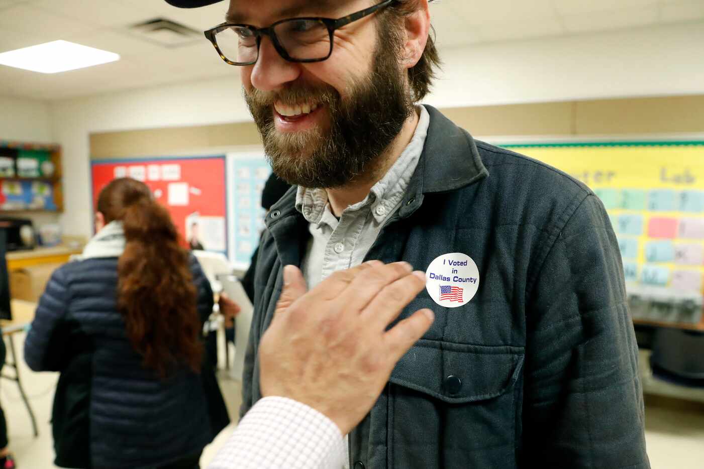 Democrat Jamie Wilson gets a sticker after voting in the Super Tuesday primary at John H....