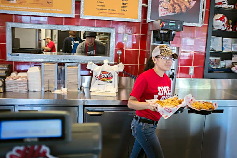 Marymar Gracia walked an order from the kitchen to a customer at Raising Cane's Chicken...