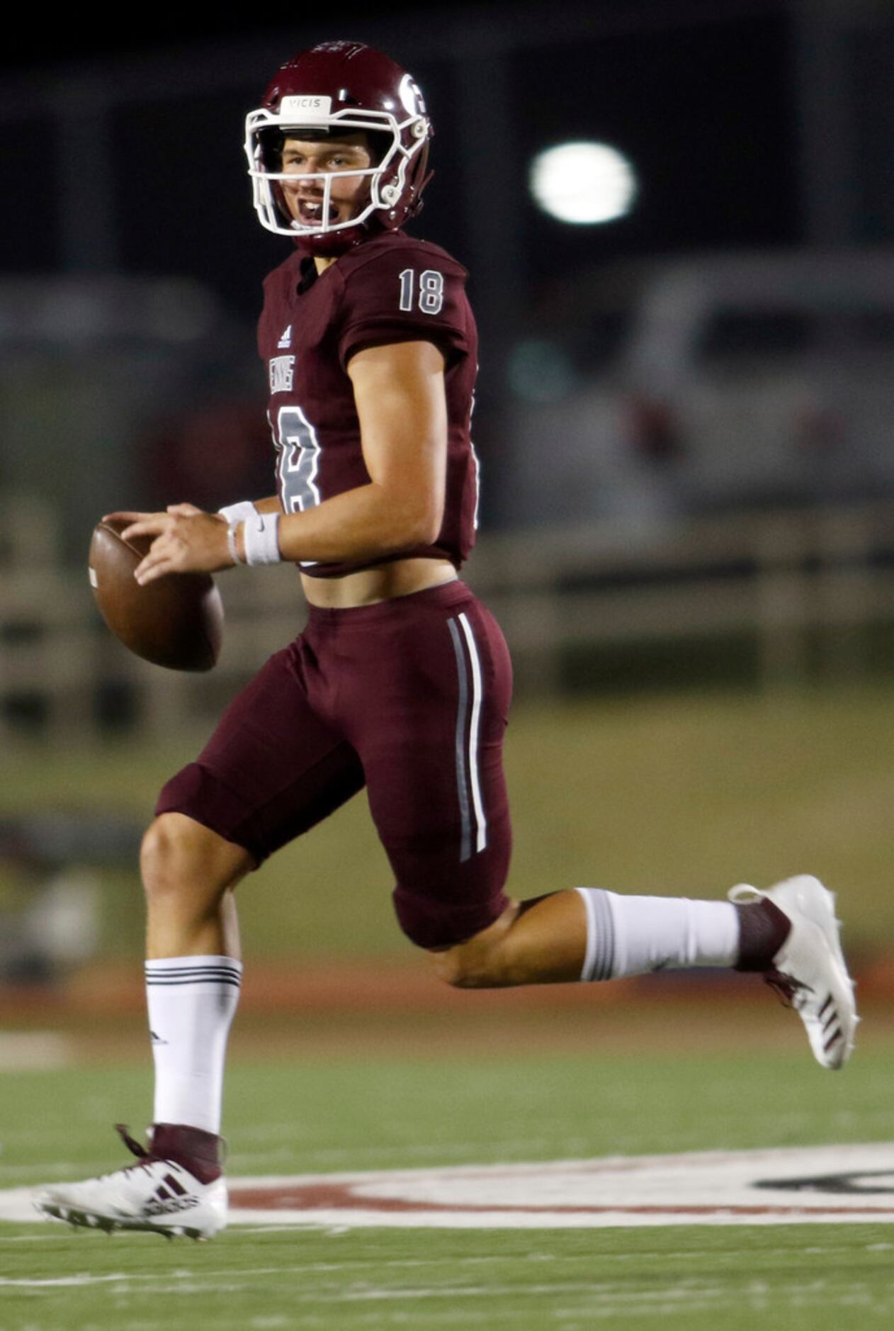 Ennis quarterback Collin Drake (18) rolls out of the pocket and keeps for a rushing first...