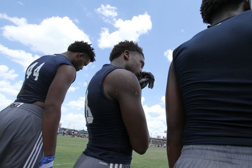 Members of the defending state champion Bishop Dunne football team watch from the sideline...