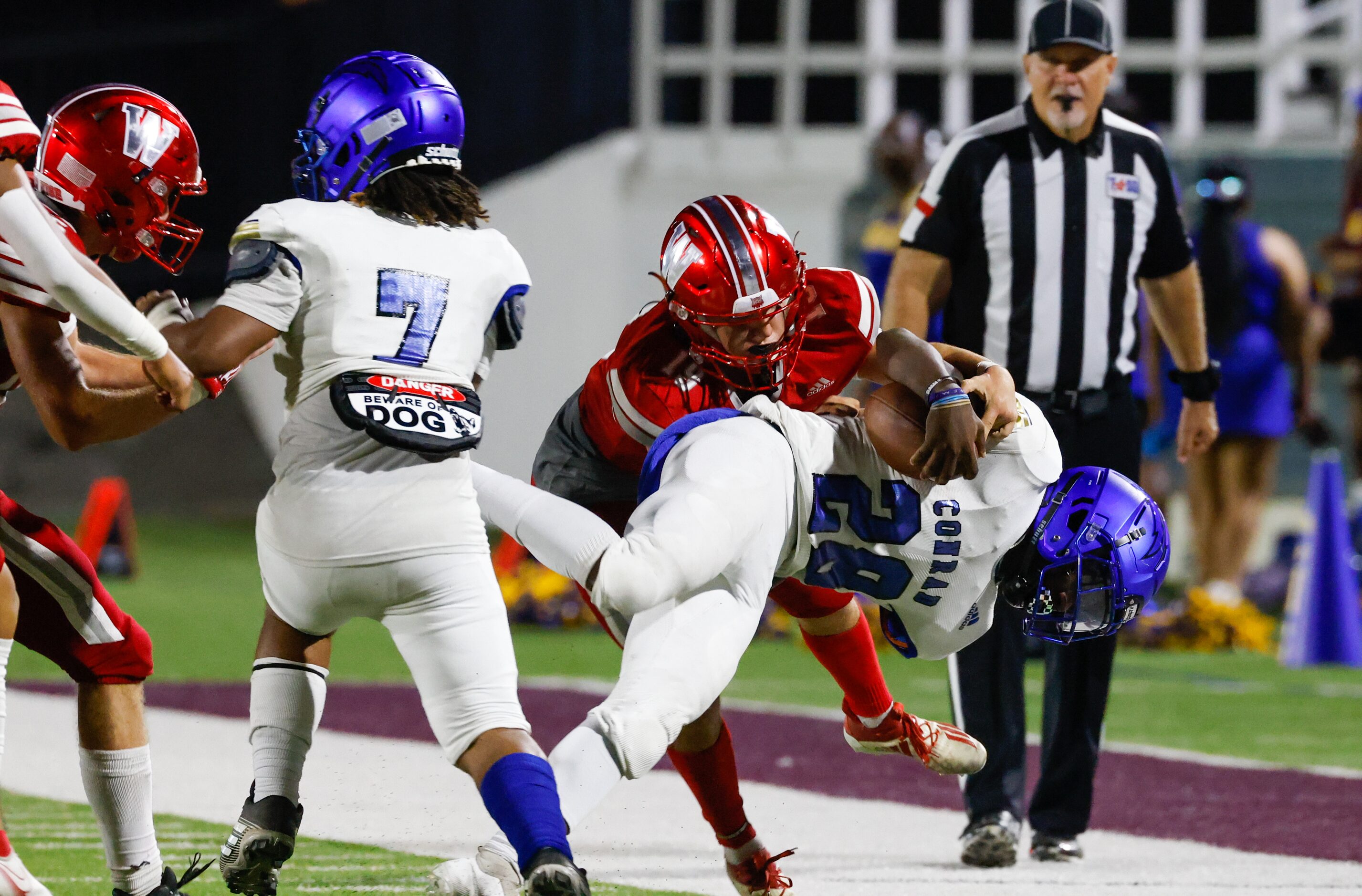 Conrad running back Marcus Johnson (28) falls as he’s tackled by Woodrow Wilson defensive...