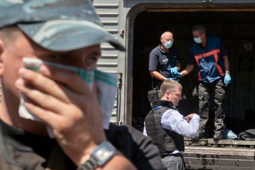 
A man covered his face with a rag Monday near a refrigerated train in Torez, Ukraine, as a...