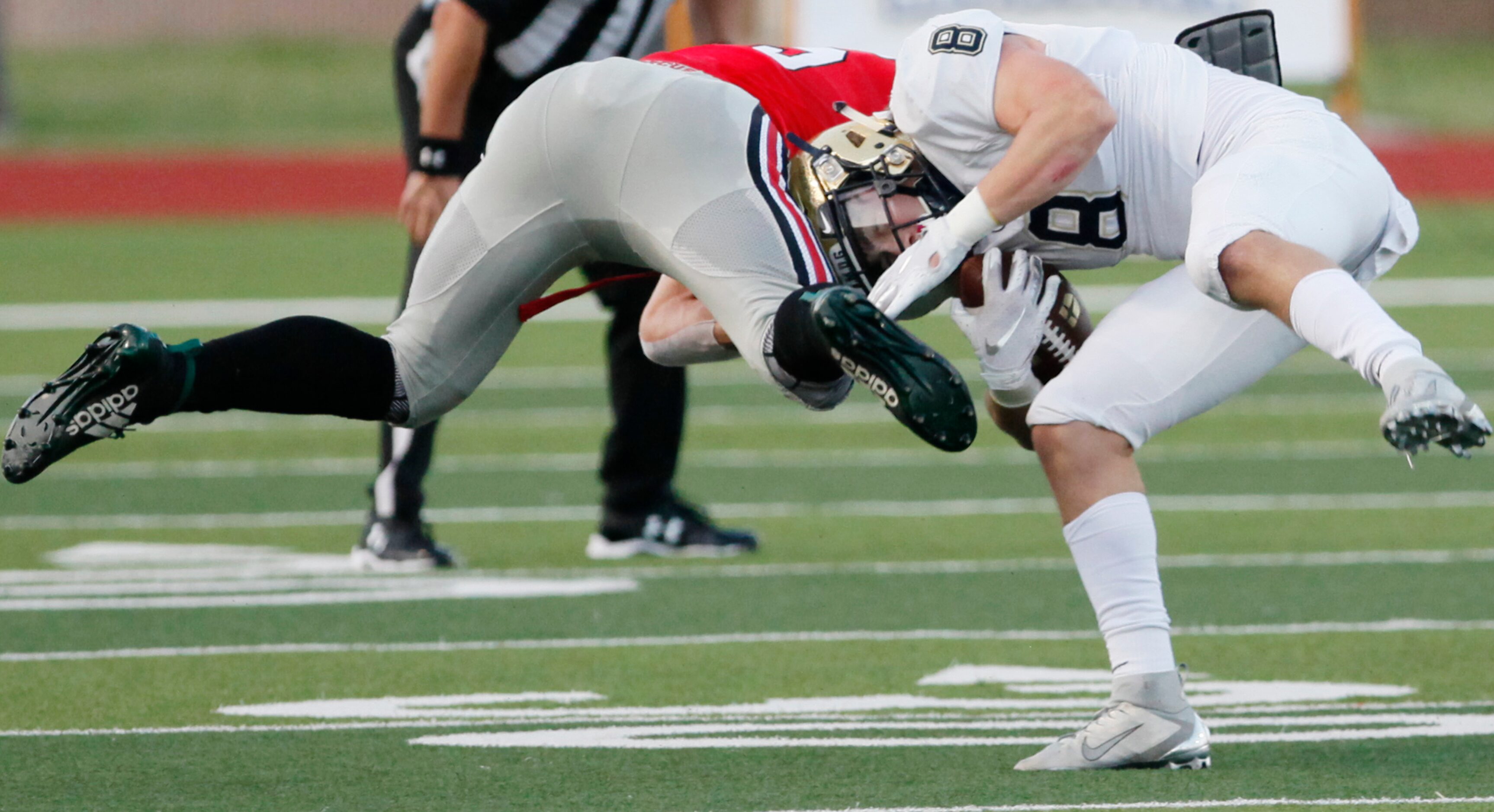 Jesuit senior running back Jake Taylor (8) is hit by Flower Mound Marcus defender senior...