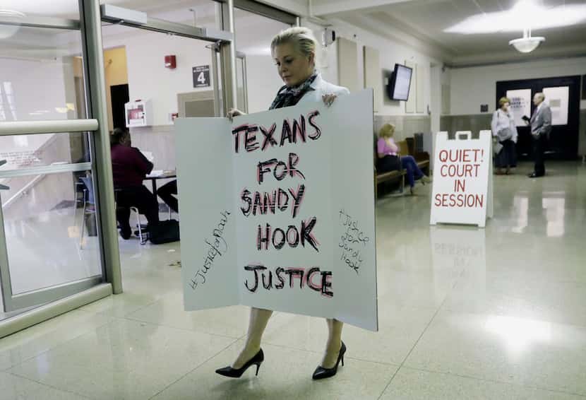 Kelly Jones, ex-wife of Infowars host Alex Jones, carries a sign as she arrives at the...