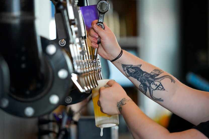 Stephanie Welch fills a beer at Thunderbird Station, which opened Sept. 17, 2020 in Deep Ellum.