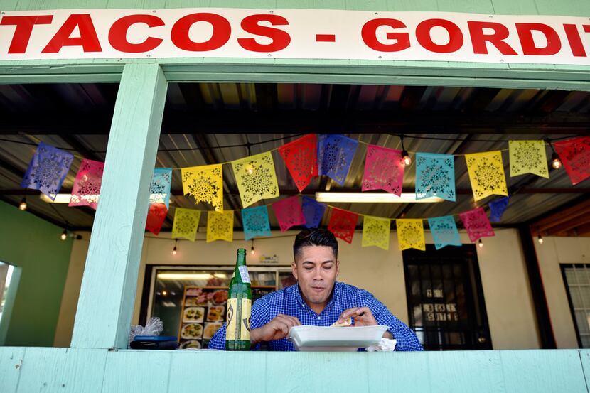 Jorge Olalde eats in a seating area outside the ordering window at Taco Garage in Dallas,...
