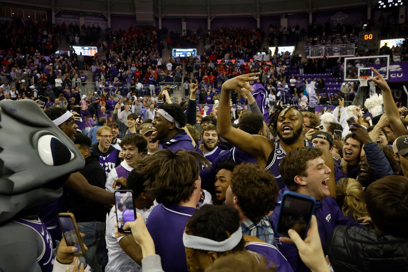 TCU fans and players, including TCU center Eddie Lampkin, center right, celebrate their...