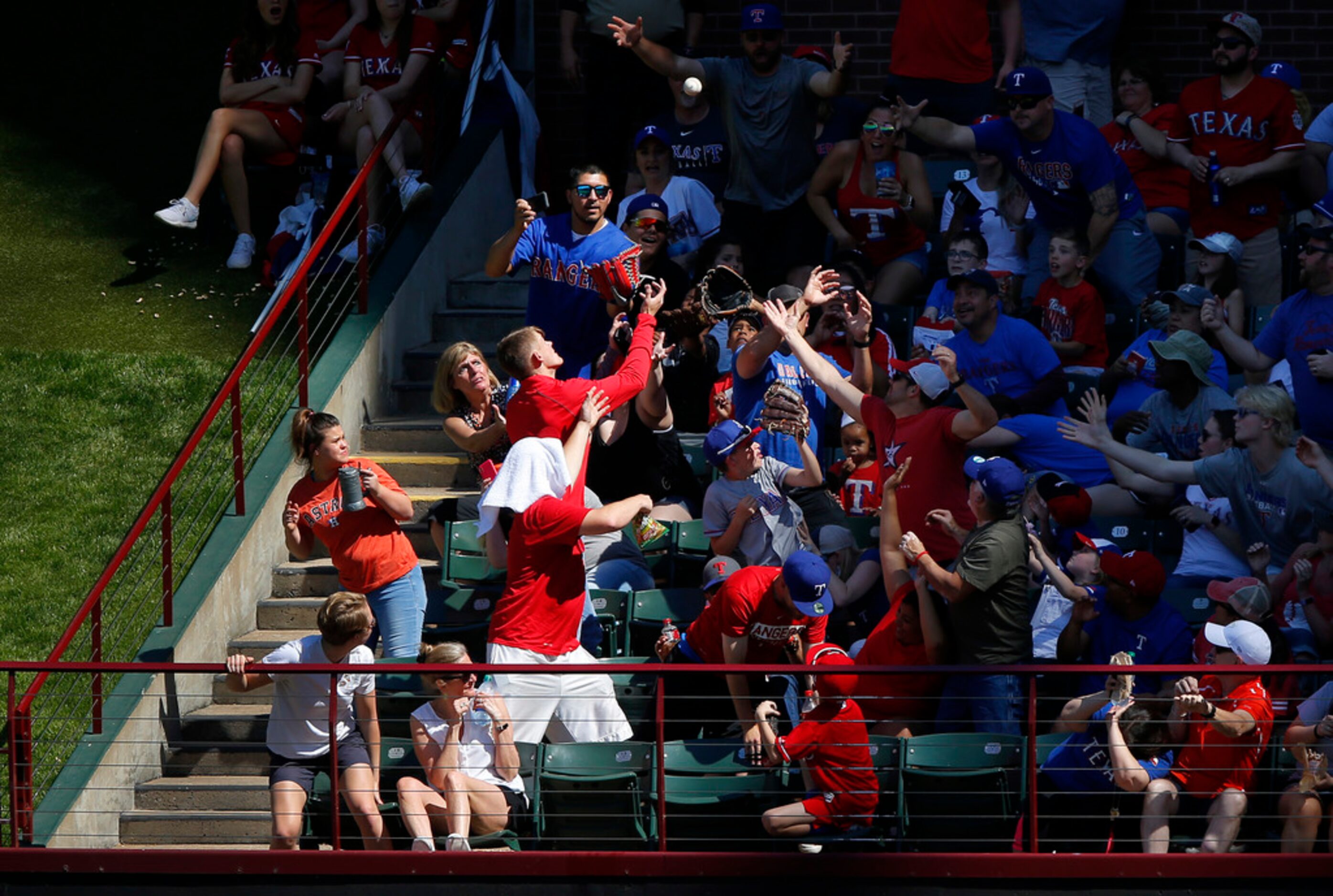 Fans reach for a Houston Astros home run ball in sixth inning against the Texas Rangers at...