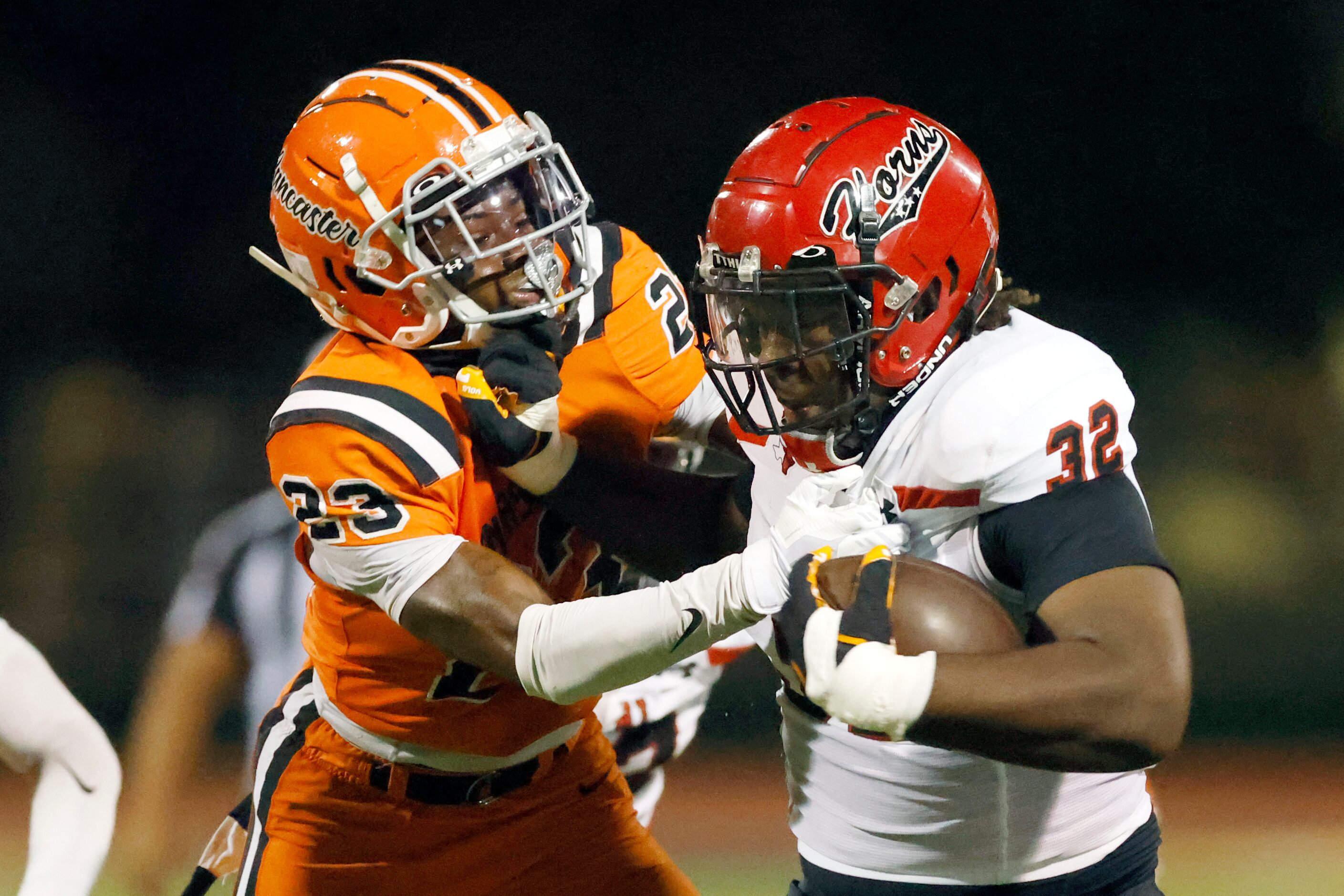 Cedar Hill running back Jalen Brewster (32) fights off a tackle by Lancaster defensive back...