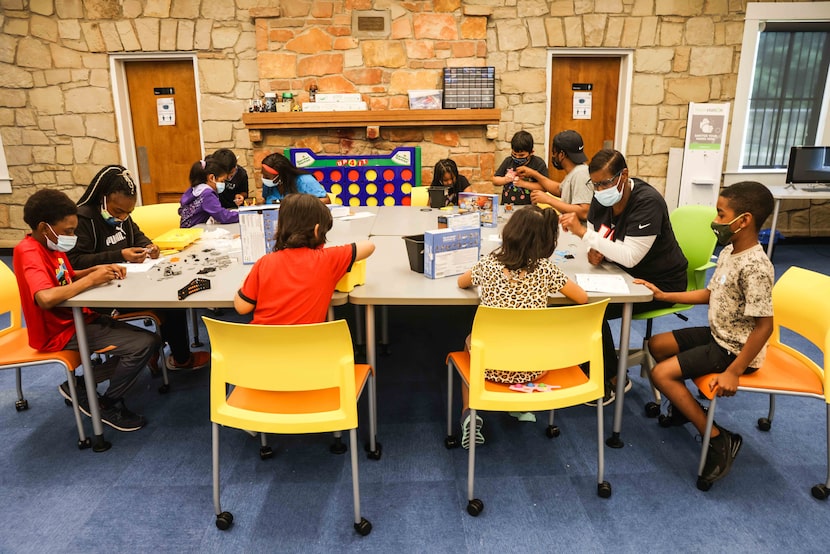 Kids work in groups on Solar Robot Creation Kits as part of the Children's Technology...