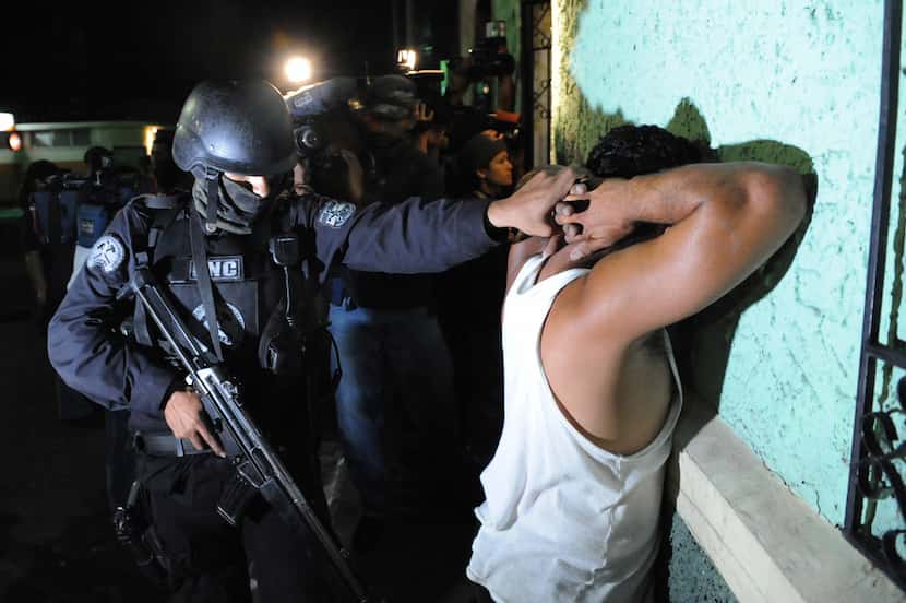 An elite police officer arrests an alleged member of the Mara Salvatrucha gang in San Juan...