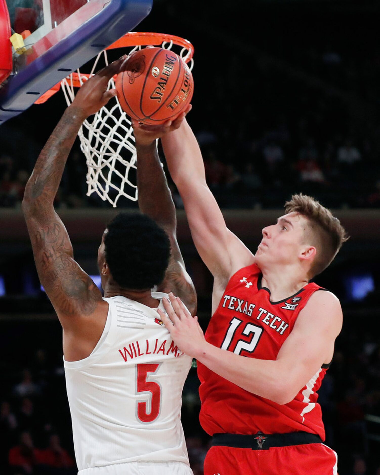 Texas Tech forward Andrei Savrasov (12) blocks a shot by Louisville forward Malik Williams...