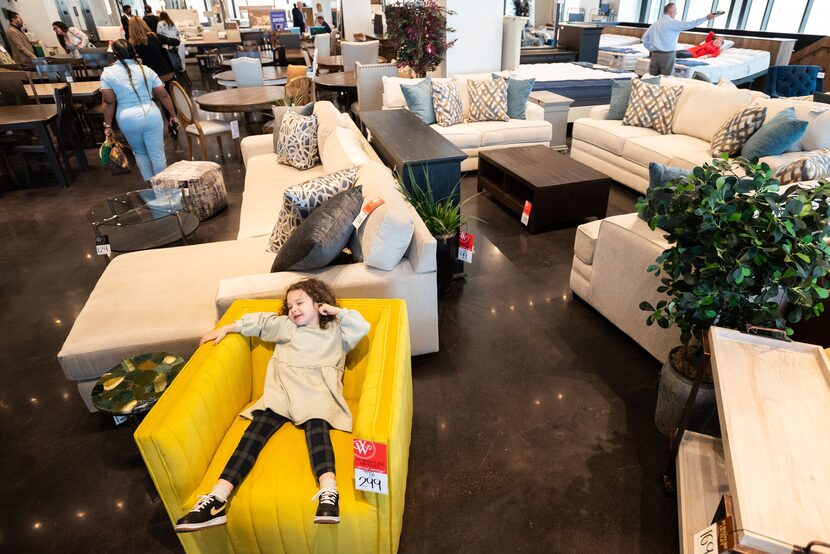 Ayla Weir, 3, relaxes in a Cobra Swivel Chair in the second-floor showoom as her family...