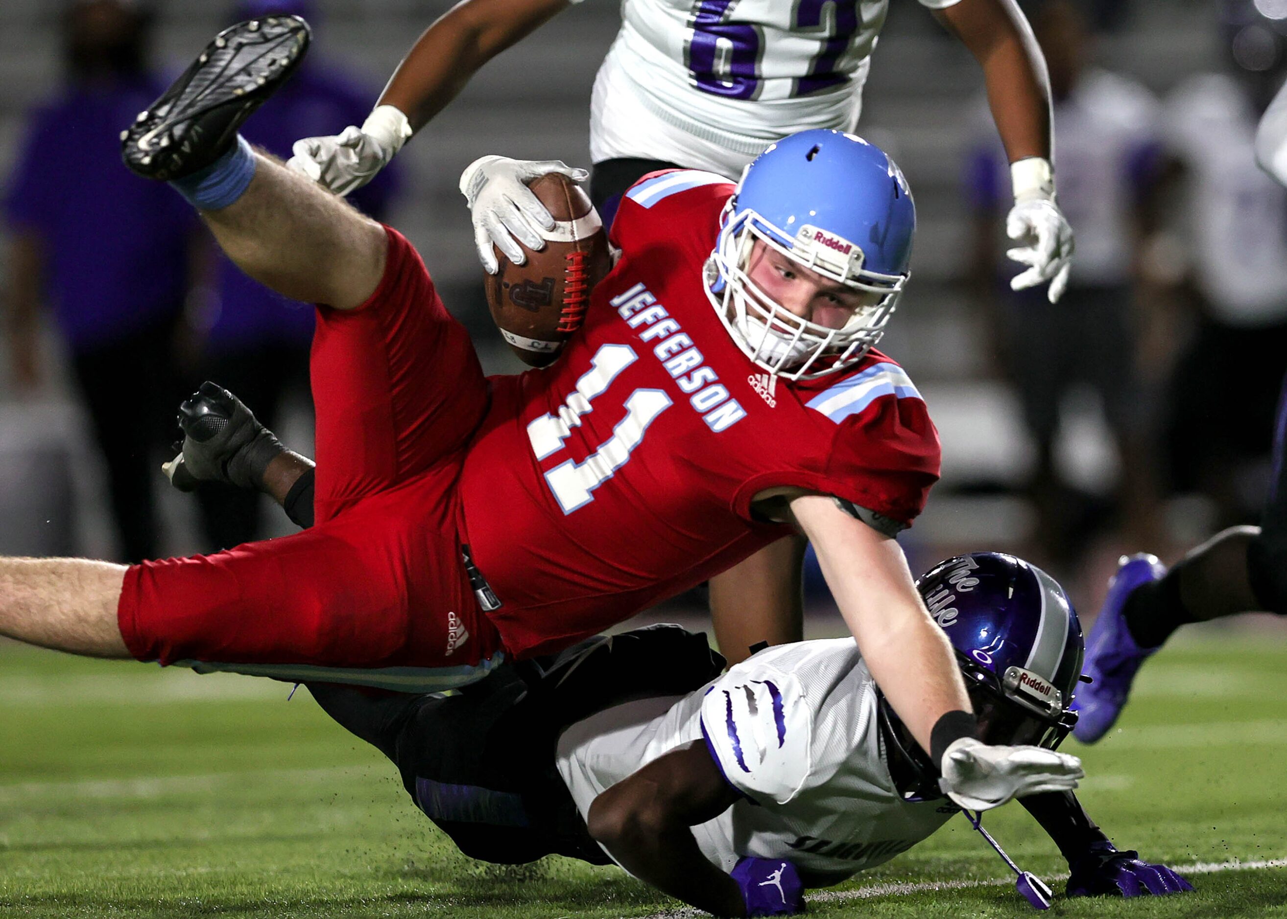 Thomas Jefferson running back Noah St. Romain (11) gets tripped up by Seagoville defensive...