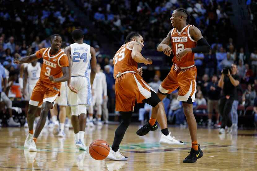 Texas' Kerwin Roach II, right, and Elijah Mitrou-Long (55) celebrate after Texas defeated...