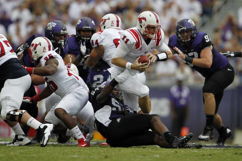 TCU's Marcus Mallet (54) tries to take down SMU's Garrett Gilbert (11) during a game for the...