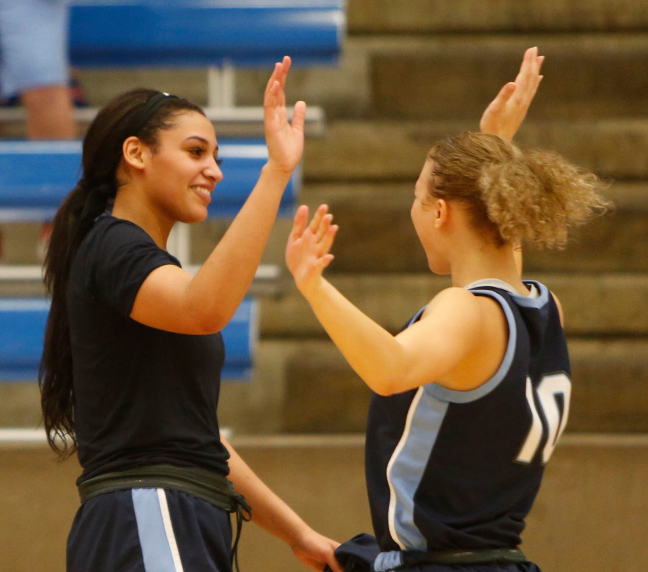 Hurst L.D. Bell guards Myra Gordon (15), left, shares a high five with Jaidyn Carter (10)...