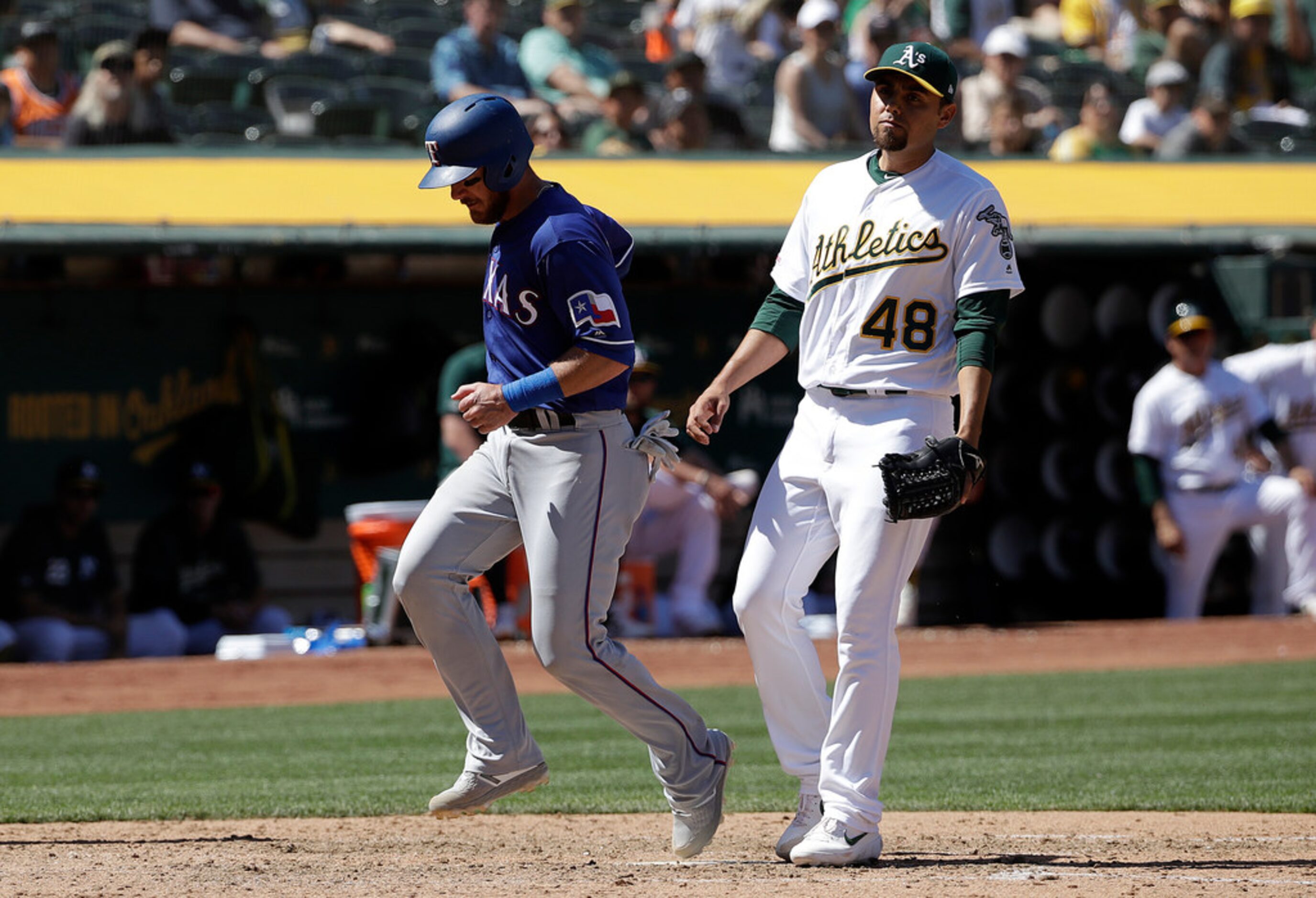 Texas Rangers' Jeff Mathis, left, scores a run past Oakland Athletics pitcher Joakim Soria...