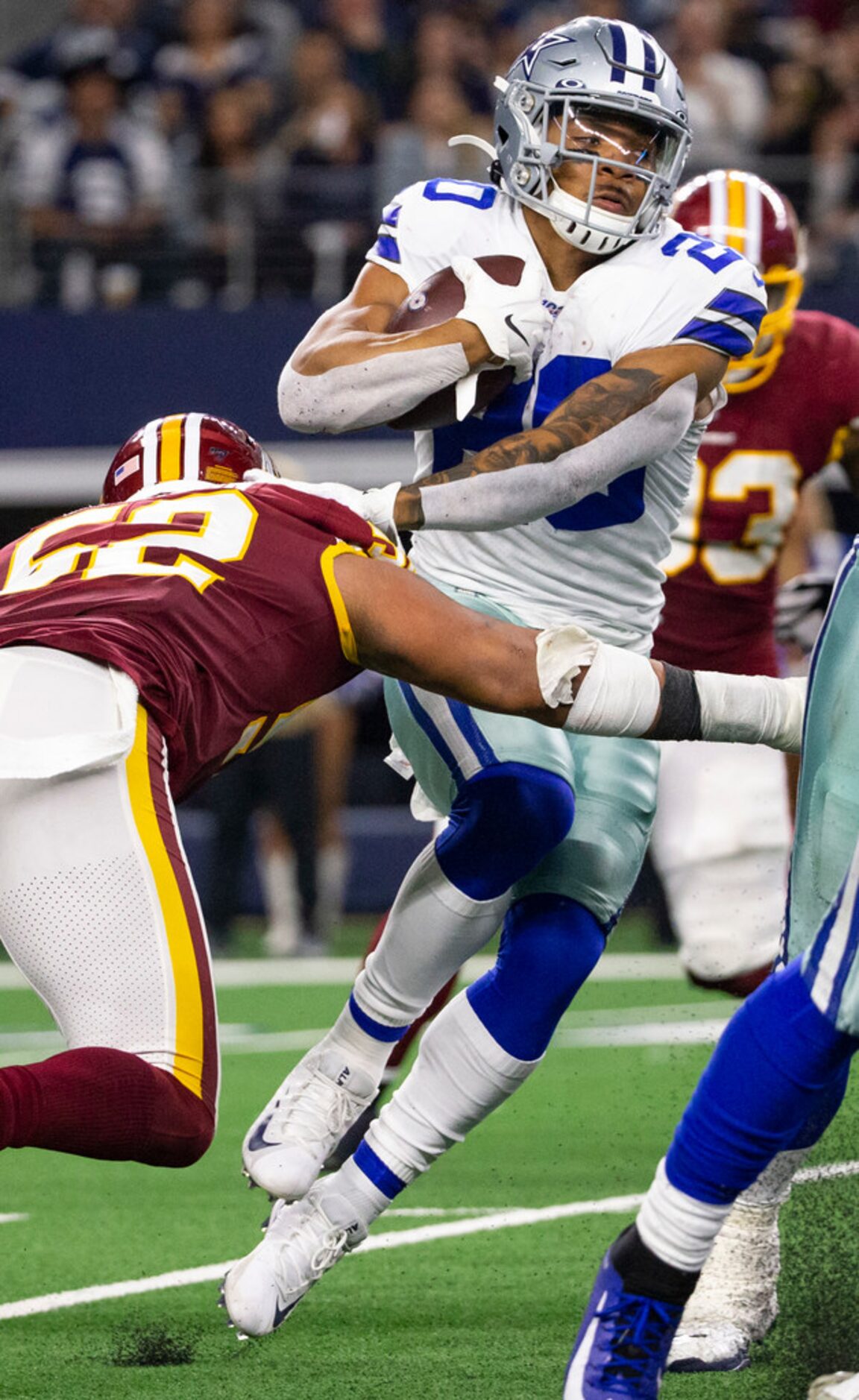 Dallas Cowboys running back Tony Pollard (20) tries to dodge a block from Washington...