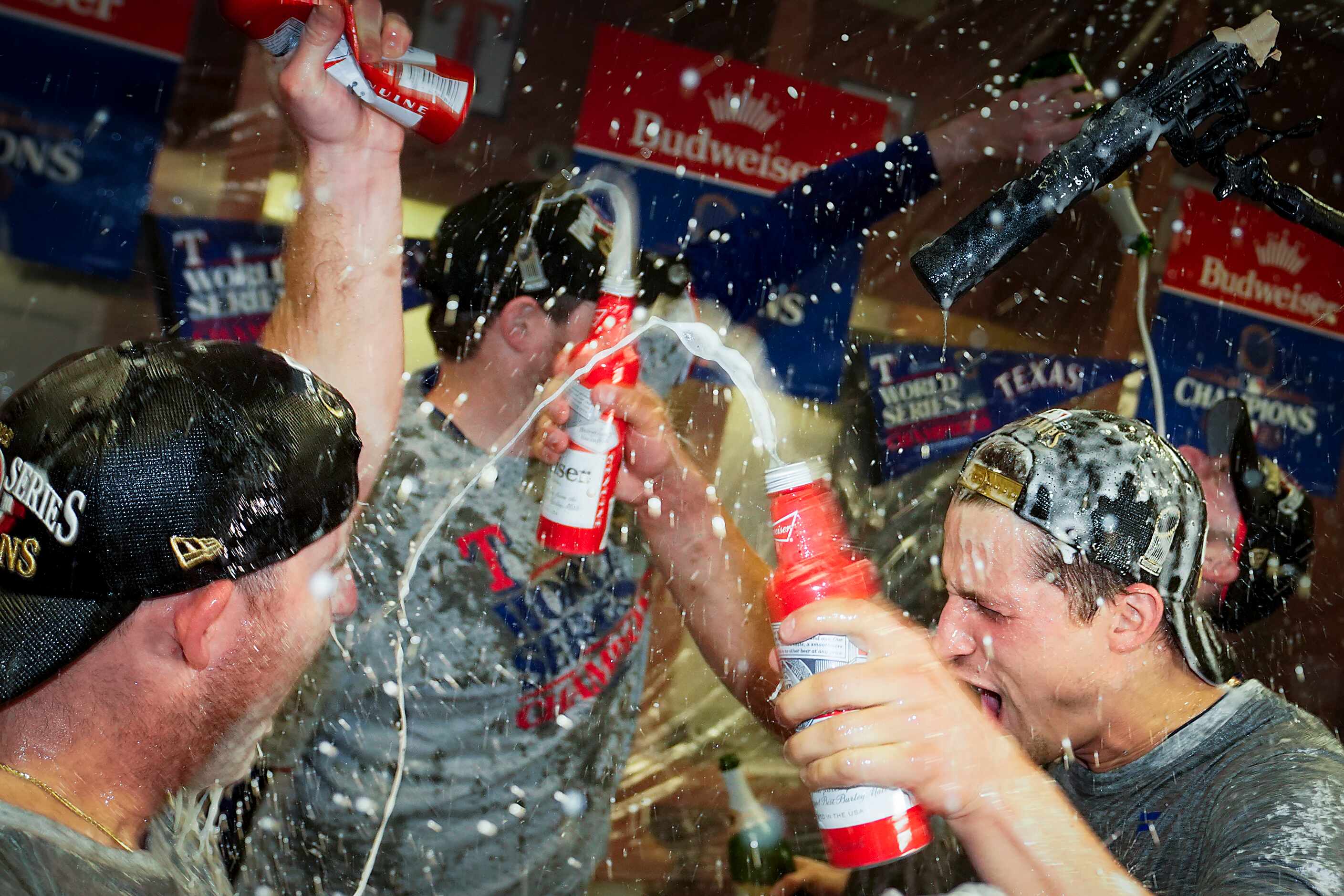 Texas Rangers shortstop Corey Seager (right) celebrates with teammates in the clubhouse...