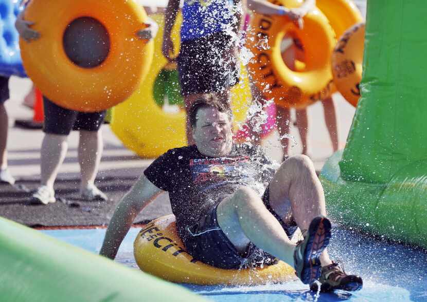 James Rhoads slides down a 1,000 foot water slide during the Slide the City event in the...