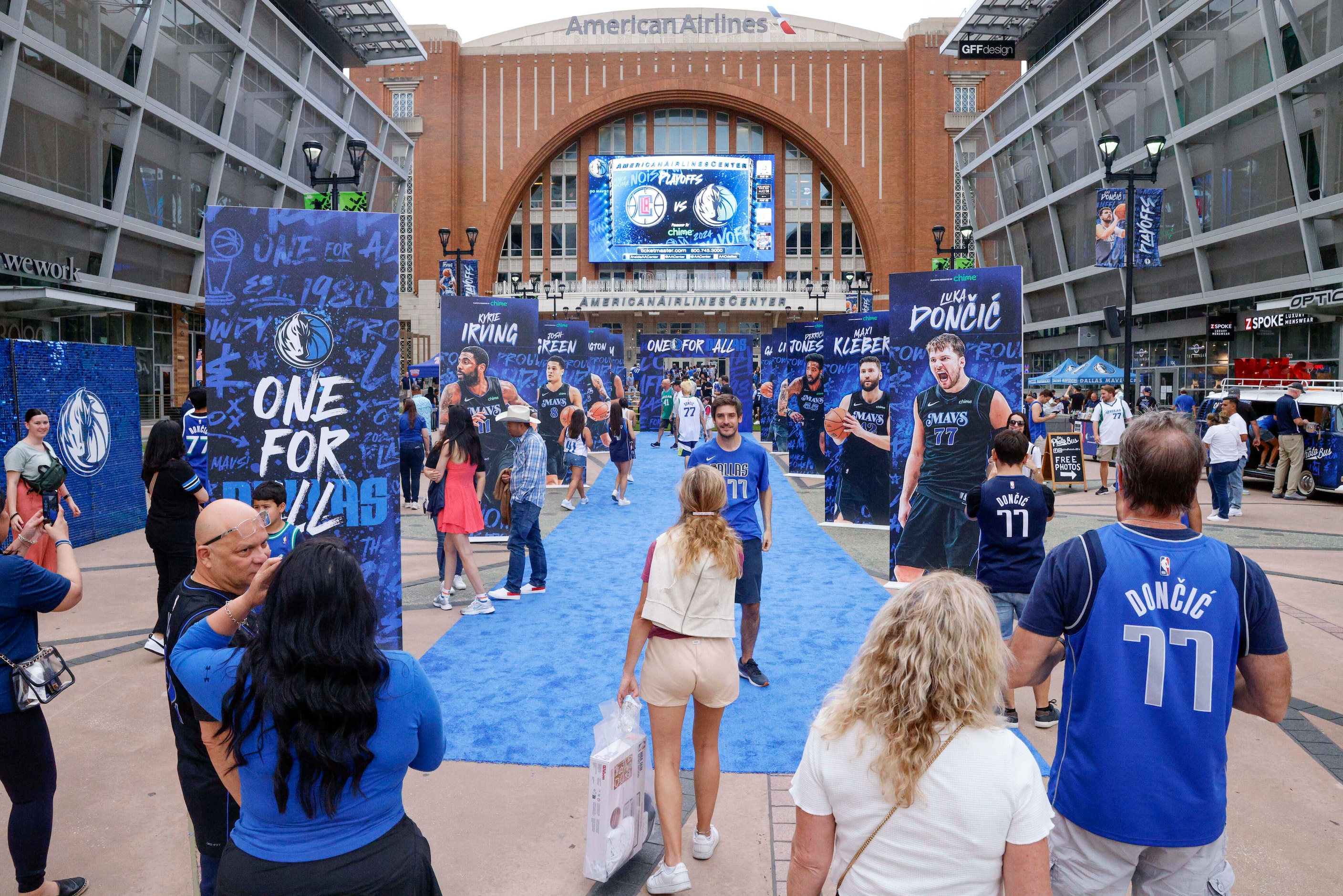 Dallas Mavericks fans walk a blue carpet and take pictures before Game 6 of an NBA...