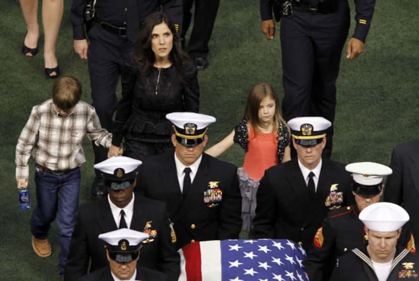 Taya Kyle and her children exit the stadium as the casket bearing Chris Kyle is carried out...