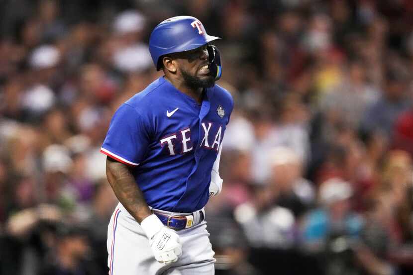 Texas Rangers’ Adolis Garcia grabs his left side after flying out in the eighth inning...