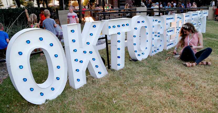 Michelle Torres of Irving sits in front of the Oktoberfest sign during Frisco’s 2019...