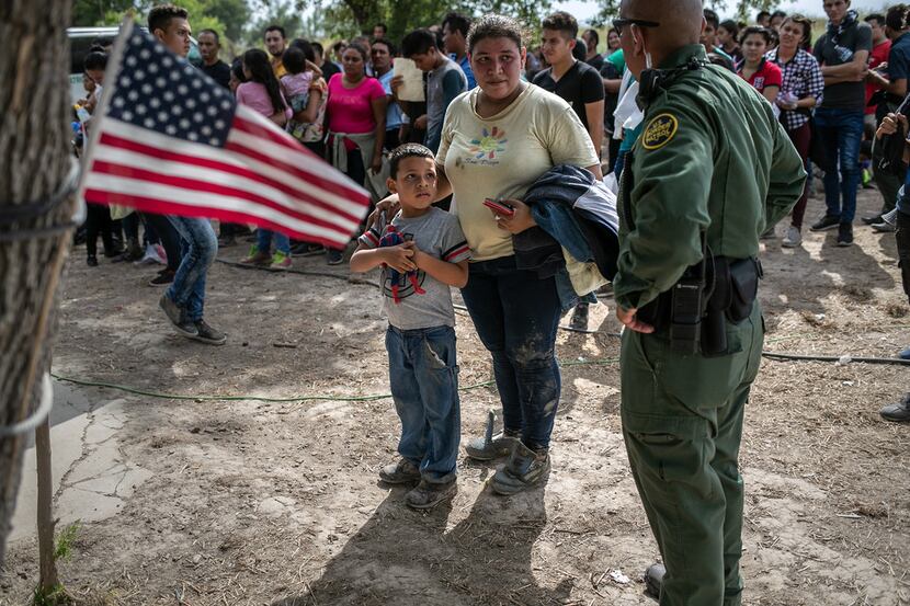 A U.S. Border Patrol agent speaks to immigrants after taking them into custody on July 2,...