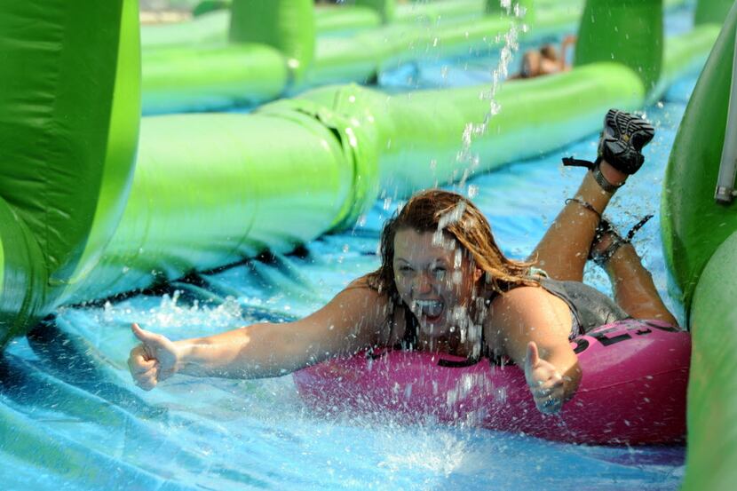 A participant slides on a tube at Slide In the City in Dallas, TX on August 22, 2015....