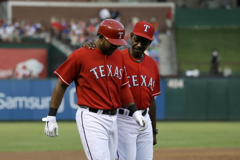 Texas Rangers' Elvis Andrus (1) is helped off the field by manager Ron Washington, right,...