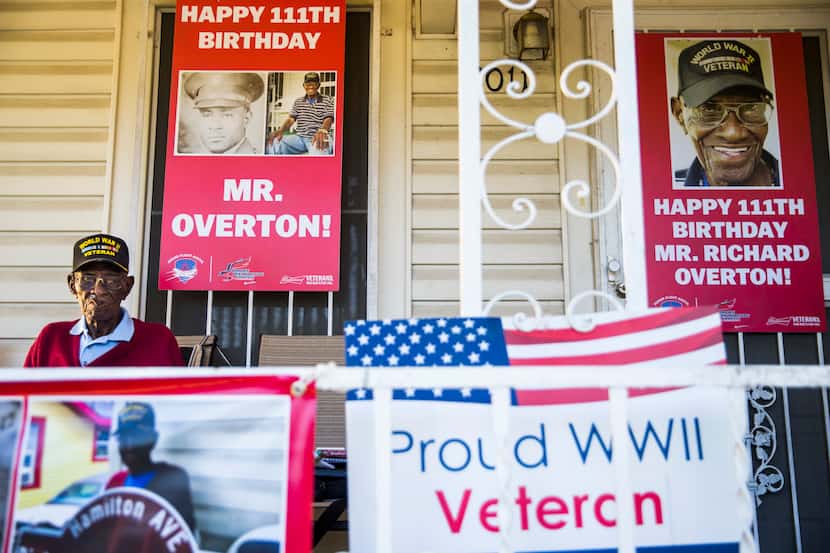 Richard Overton, 111, smokes a cigar on his Austin front porch among signs from his recent...