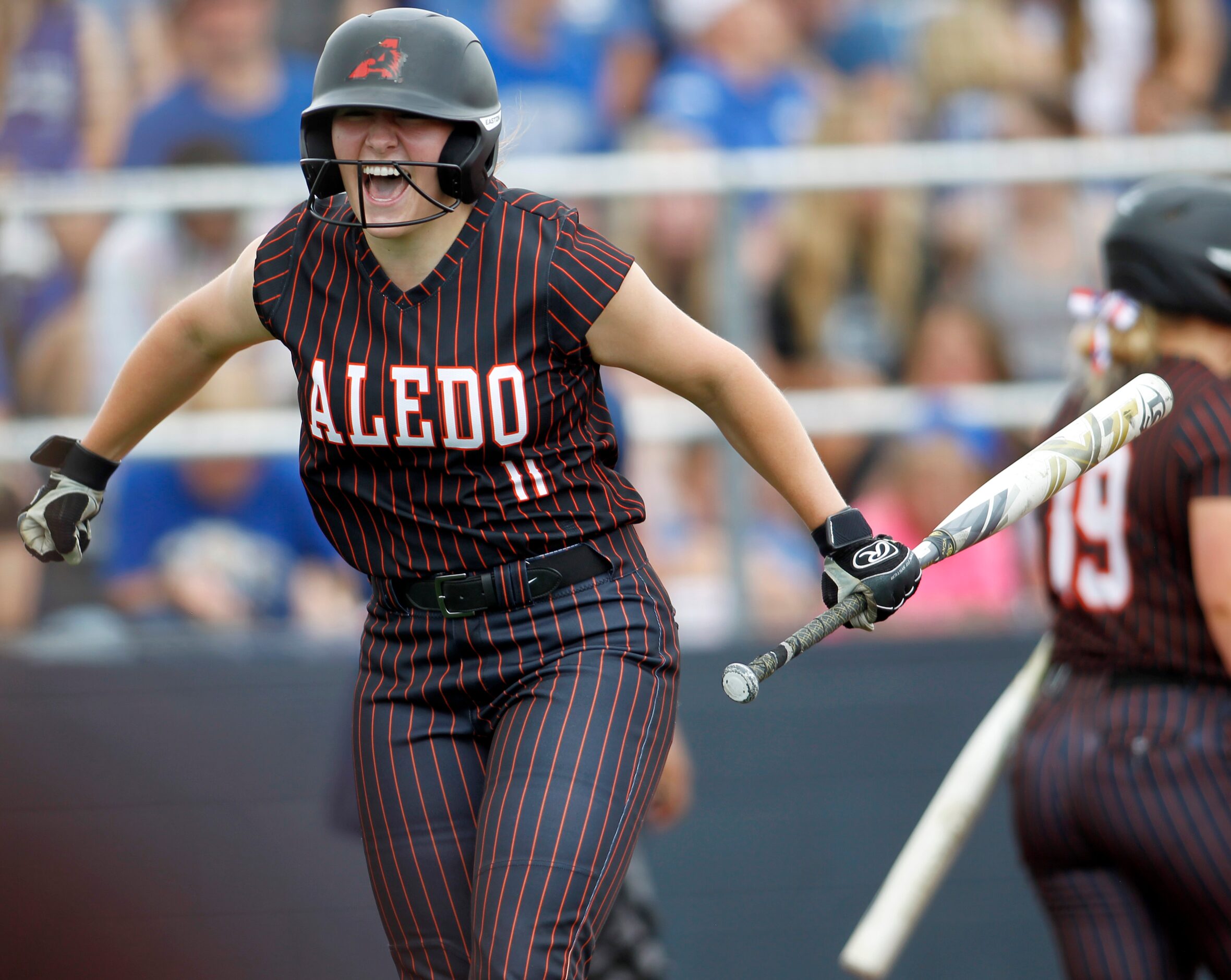 Aledo outfielder Marissa Powell (11) leaps in celebration after scoring after reaching...