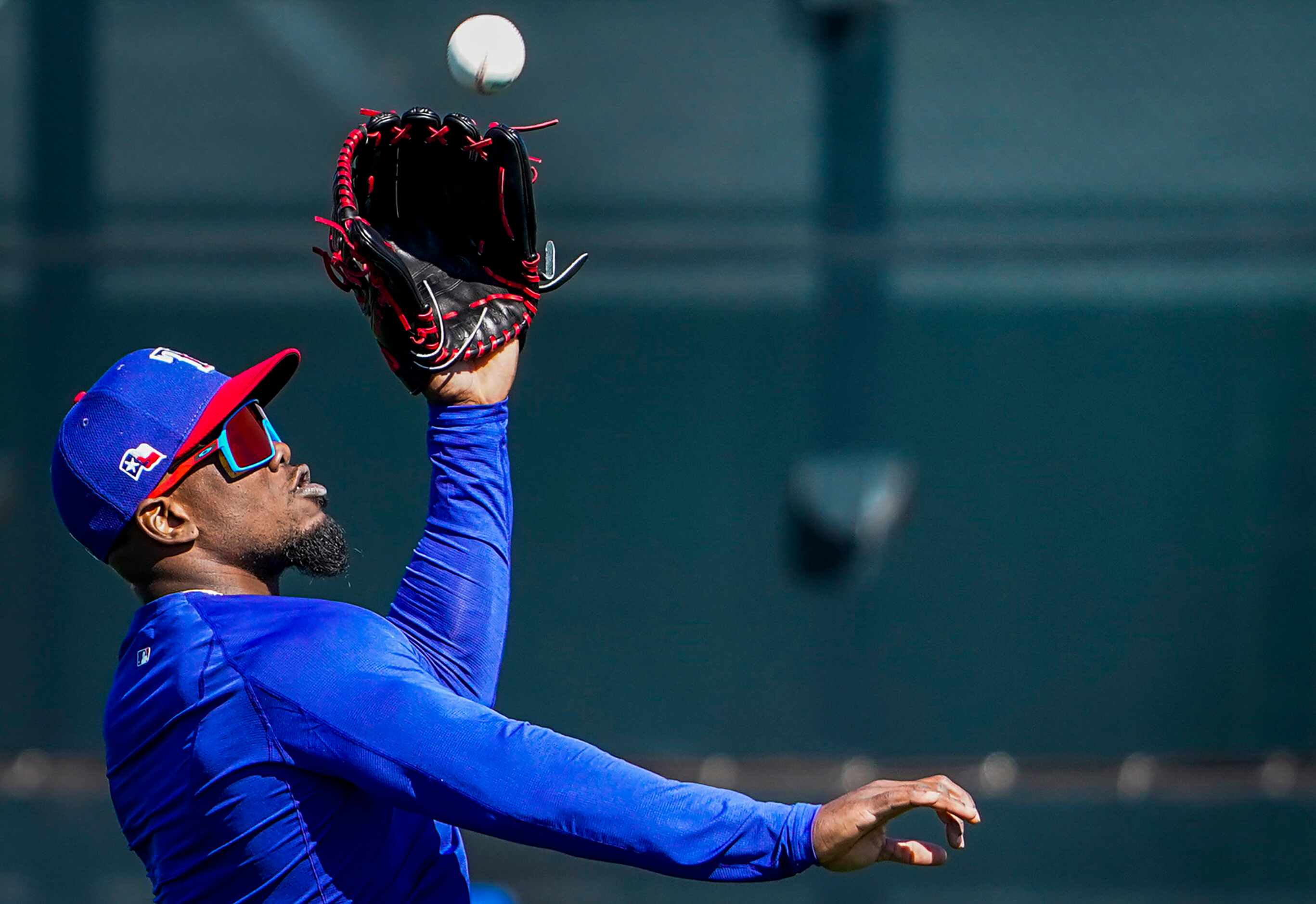 Texas Rangers outfielder Adolis Garcia makes a catch during a spring training workout at the...
