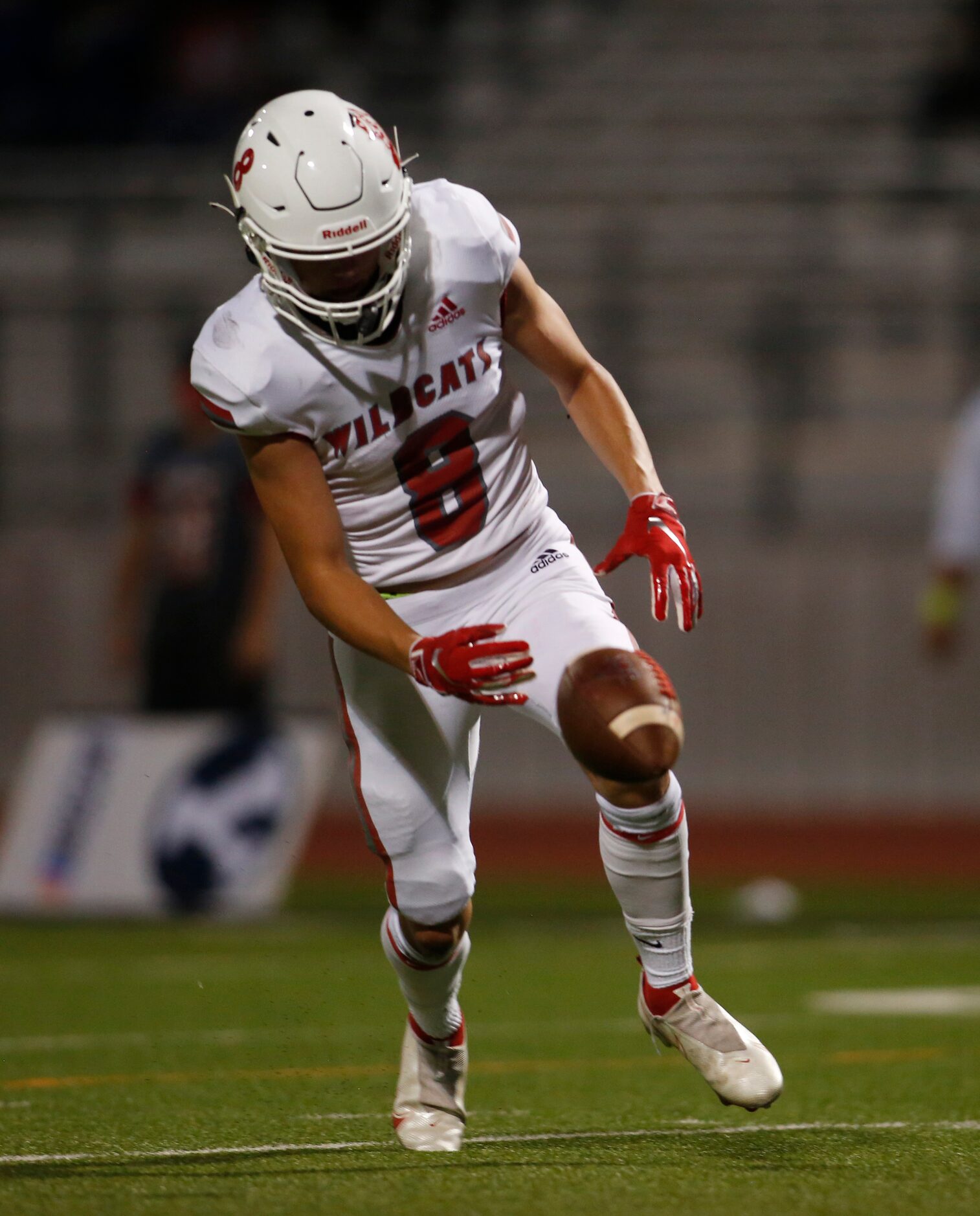 Dallas Woodrow Wilson punter Benjamin Smith (8) reaches to field an errant snap during first...